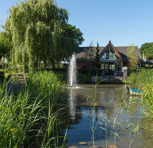 tuinhuys met de vijver op de voorgrond